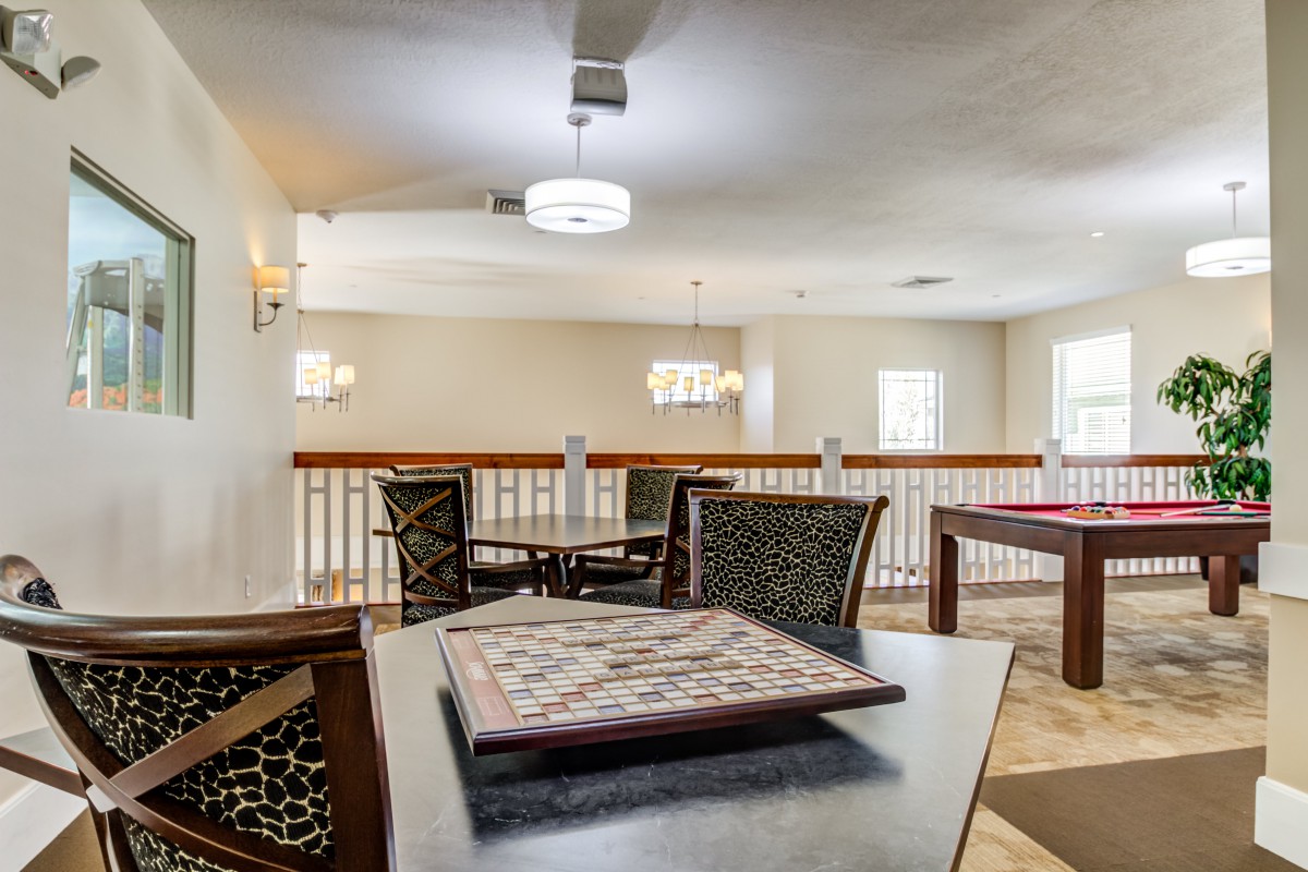 A cozy game room equipped with a chessboard and modern lighting.