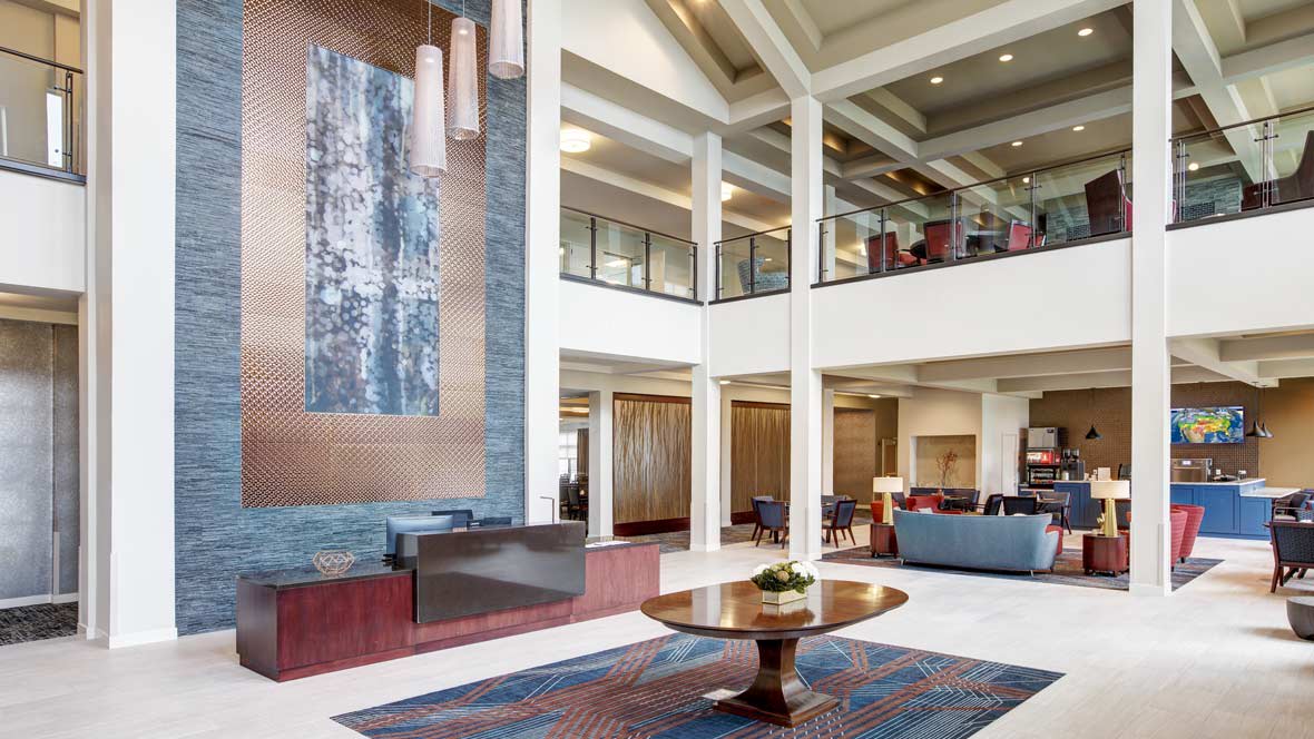 A modern and spacious hotel lobby with elegant interior design and decorative artwork.