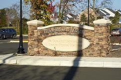 An entrance sign for the Woodhaven Lakes community, featuring a stone design.
