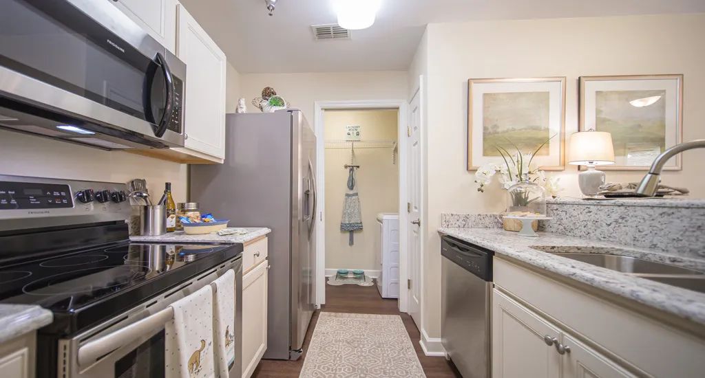 A modern kitchen with white cabinets and stainless steel appliances.