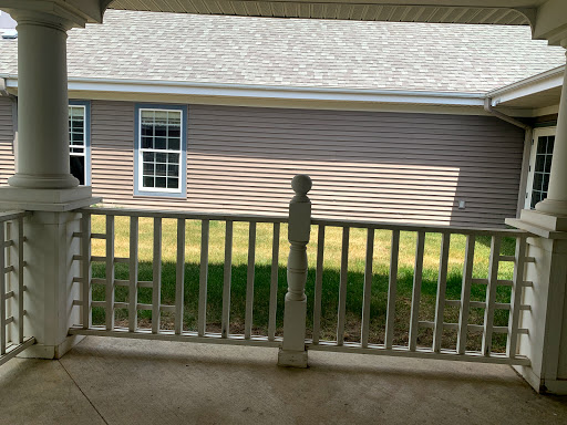 A view of the backyard from a porch, showcasing the house next door and greenery.
