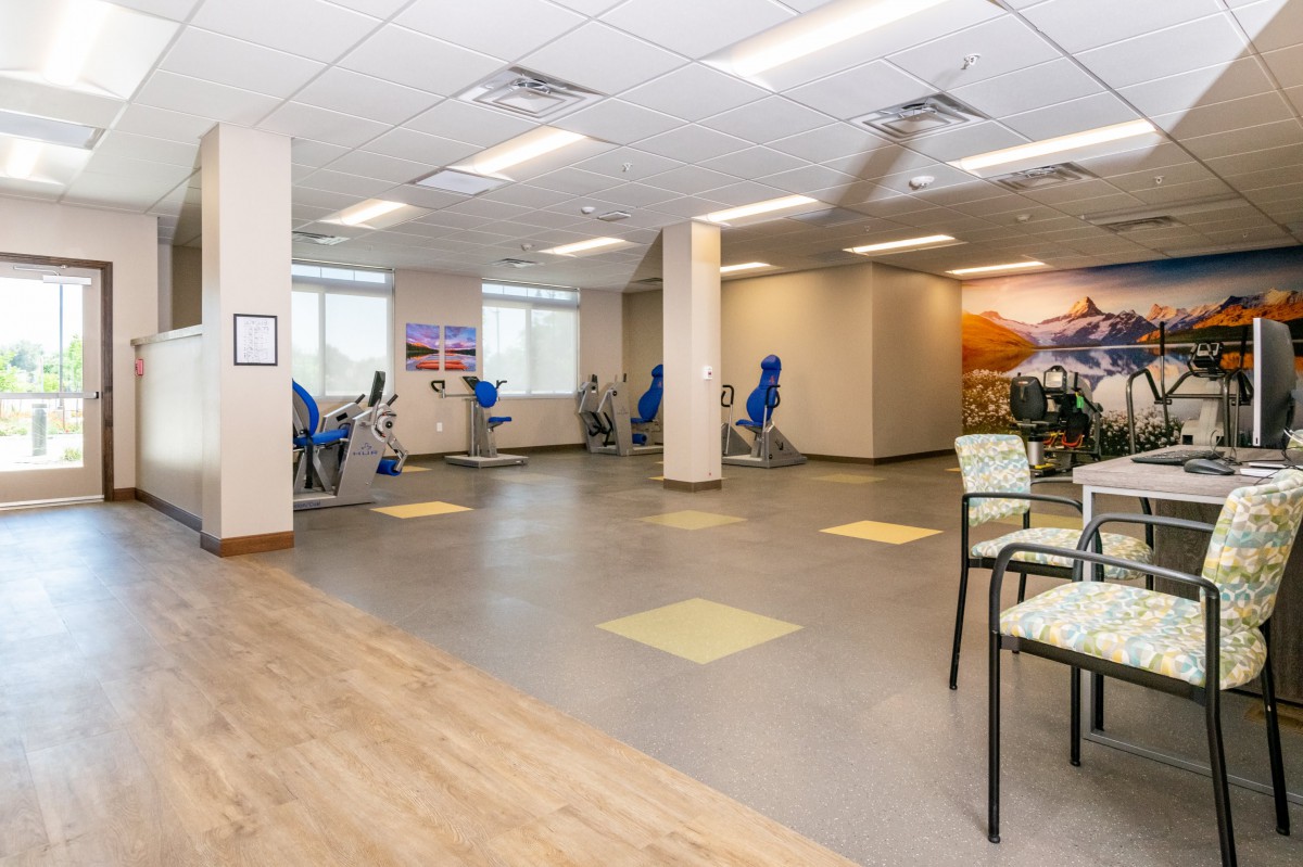 An empty gym with exercise equipment lined up and a spacious workout area.