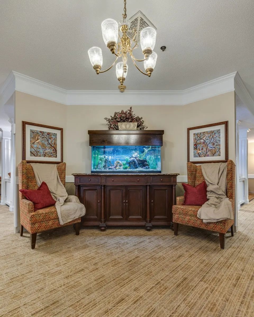 A cozy living room interior with an aquarium and comfortable seating.