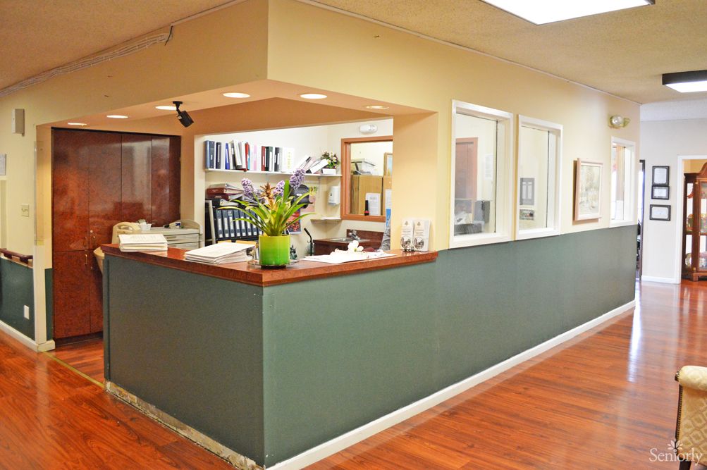 A well-organized office reception area with a front desk and floral decor.