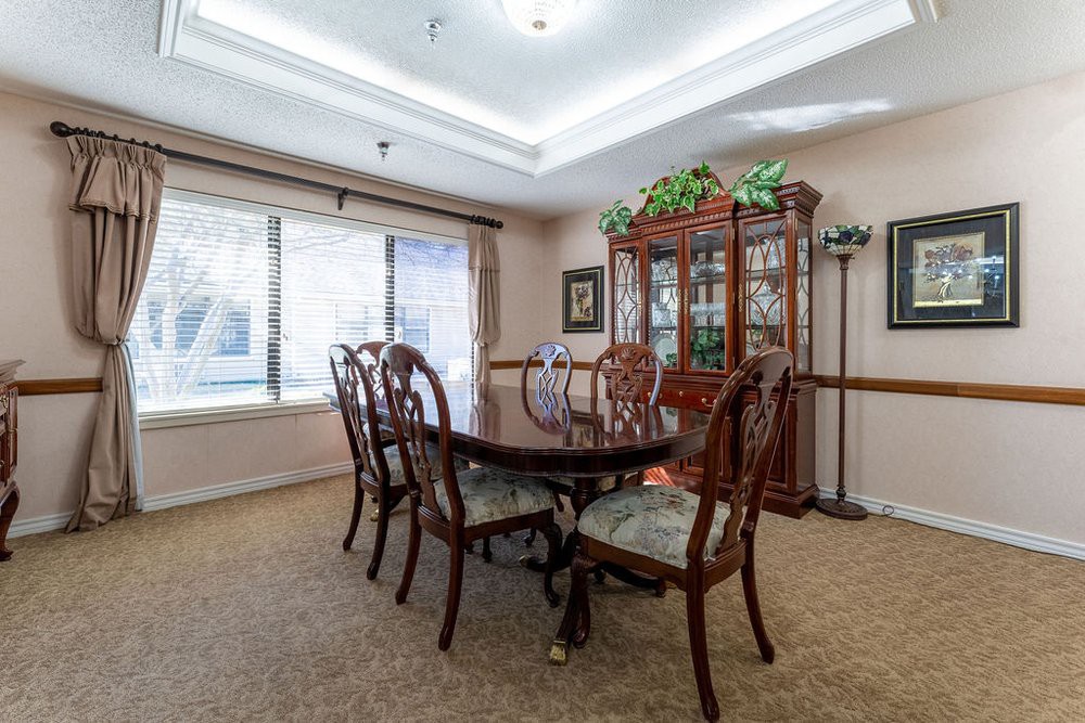 A traditional dining room with a wooden table, chairs, and a glass-front cabinet.