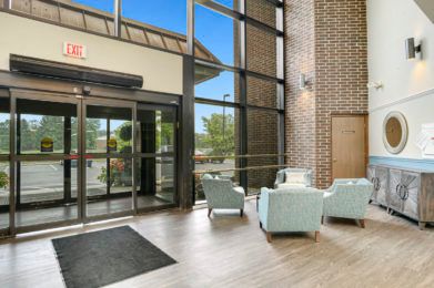A modern lobby with comfortable seating and large glass doors allowing natural light to fill the space.
