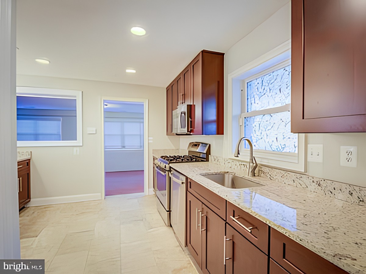 A modern kitchen with wooden cabinets and stainless steel appliances.