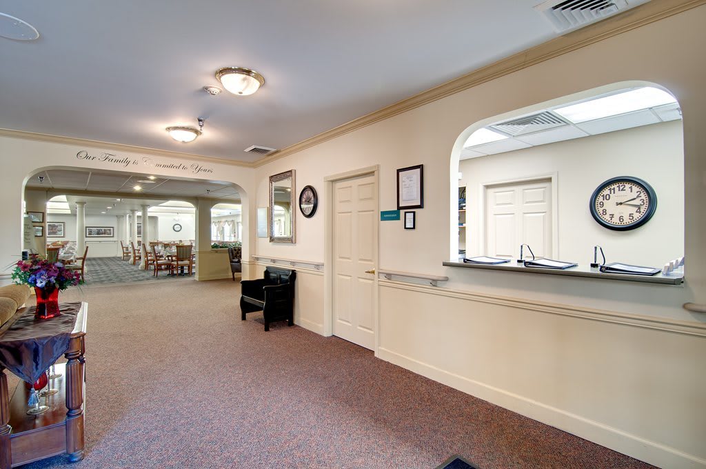 A reception area with a waiting room and hallway, featuring seating and interior decor.