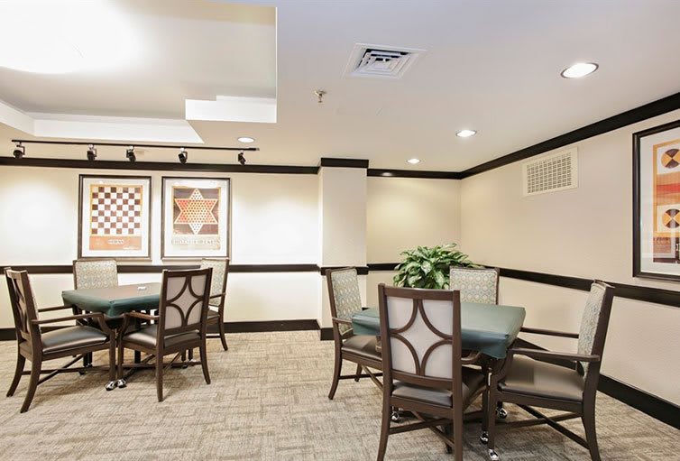 A cozy dining area with tables, chairs, and wall artwork.