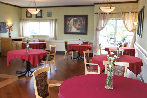 A cozy dining area featuring red tablecloths and artistic wall decor.