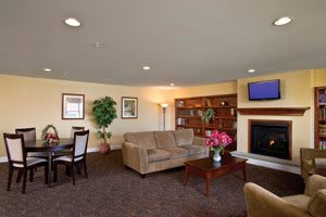 A cozy living room with a sofa, coffee table, television, and bookshelves.