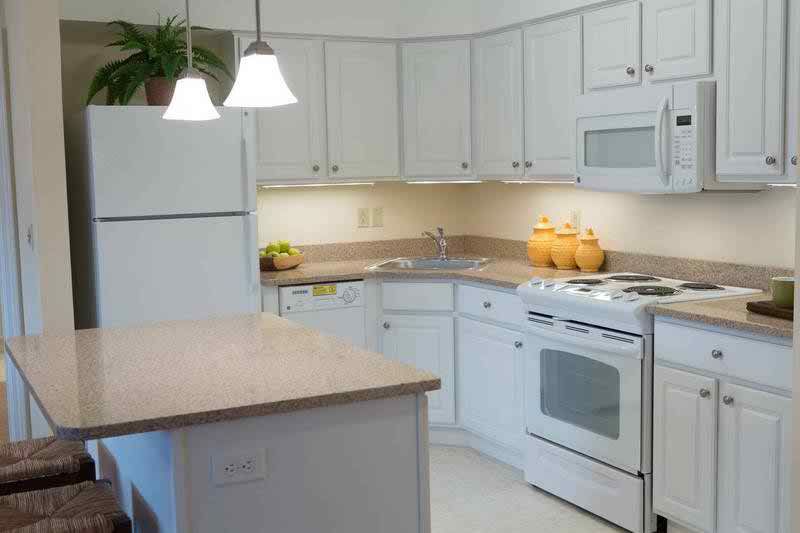 A modern kitchen with white cabinets and appliances.