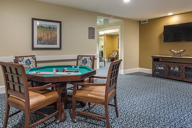 A cozy game room featuring a poker table with chairs and wall artwork.