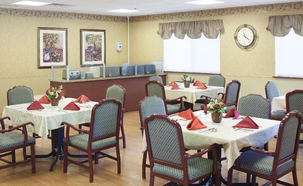 A cozy dining room with neatly set tables and colorful napkins.