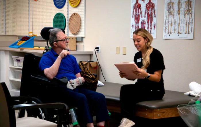 A therapy session in progress with a patient and a therapist discussing treatment plans.