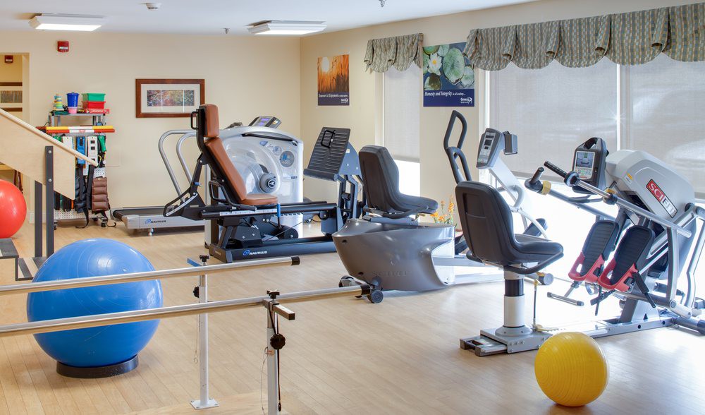 A well-equipped fitness center with various exercise machines and rehabilitation tools.