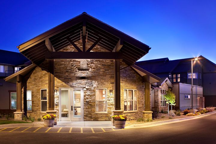 A warmly lit building entrance with a stone facade, captured at night.