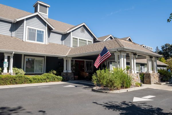 A residential building with an American flag displayed at the entrance.