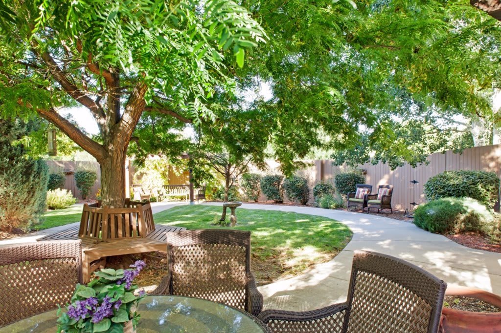 A serene garden with outdoor seating and lush greenery.