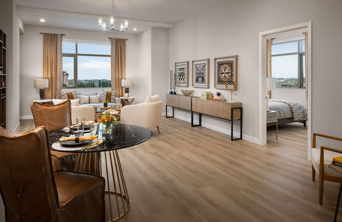 A modern open-space living and dining area with elegant decor and wooden flooring.
