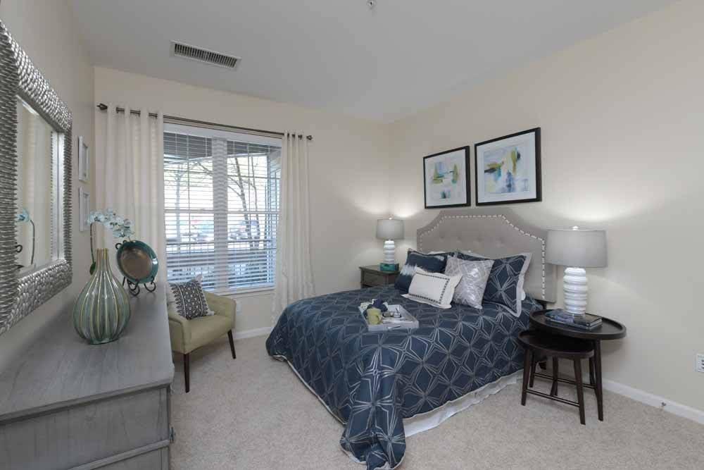A cozy bedroom with elegant decor and a large window.