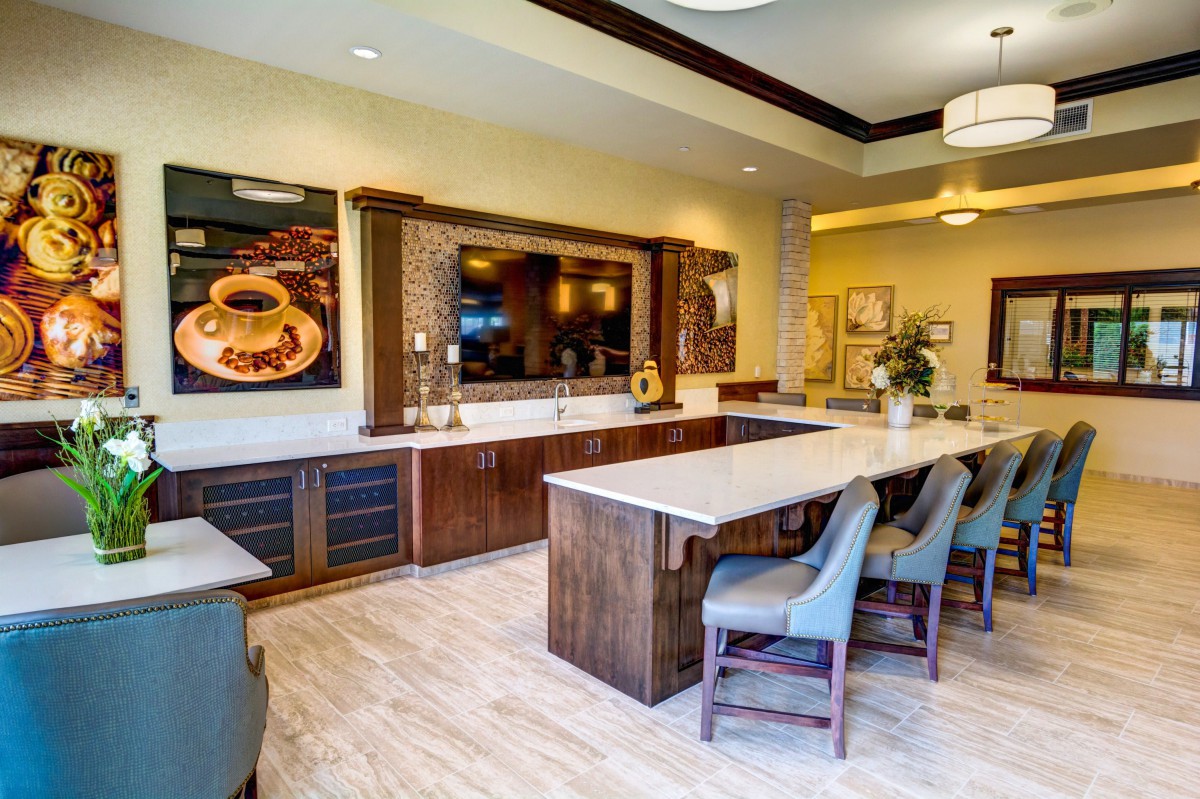 A modern kitchen interior with a large island counter and wooden cabinets.