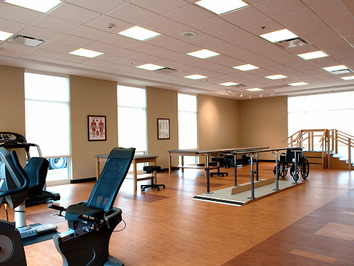 A well-lit rehabilitation space equipped with exercise equipment and a welcoming atmosphere.