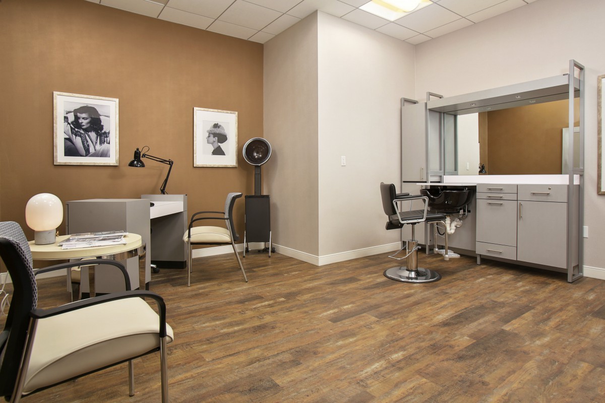 A modern salon interior with stylish furniture and wooden flooring.
