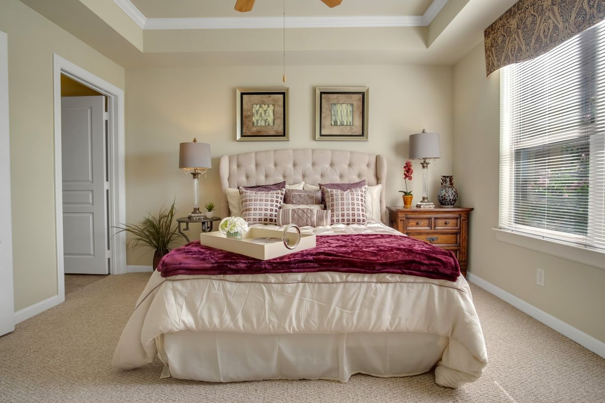 A luxurious bedroom with elegant decor, featuring a plush bed and stylish lamps.