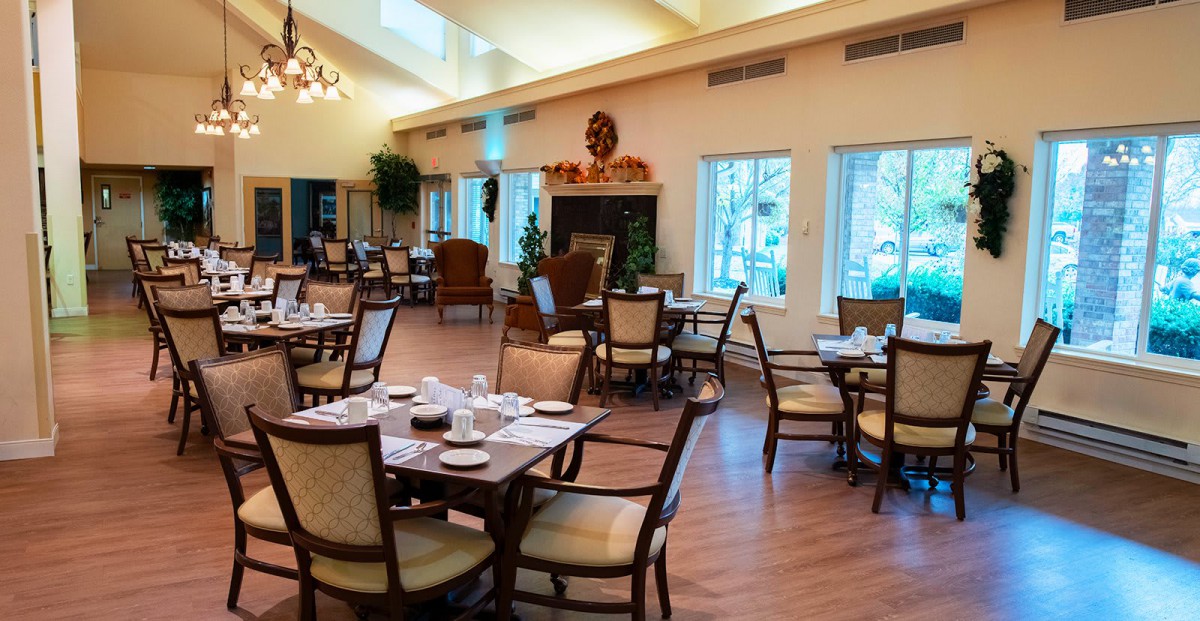 A spacious dining area with neatly arranged tables and chairs, featuring natural lighting and elegant decor.