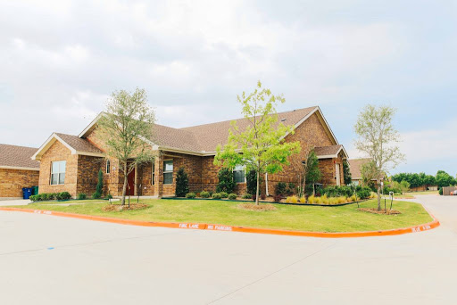 A charming brick house surrounded by well-maintained landscaping.