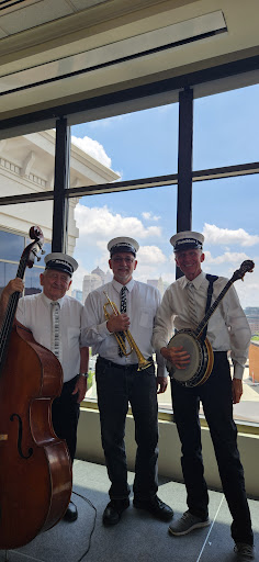 A lively jazz band poses for a photo, showcasing their instruments and upbeat spirit.