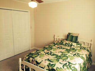 A cozy bedroom with floral bedding and simple decor.