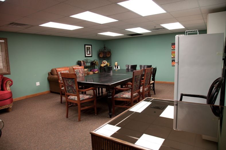 A well-lit conference room with a large table and several chairs, suitable for meetings.