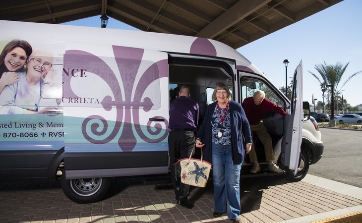 People exiting a service van under a canopy.