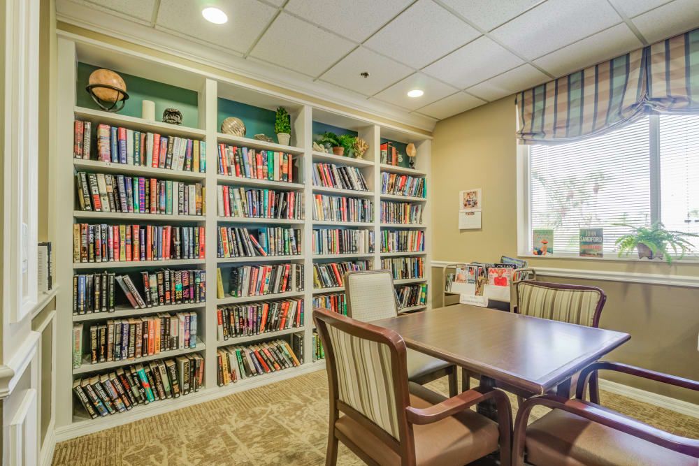 A cozy library corner with bookshelves, a table, and chairs for reading and study.