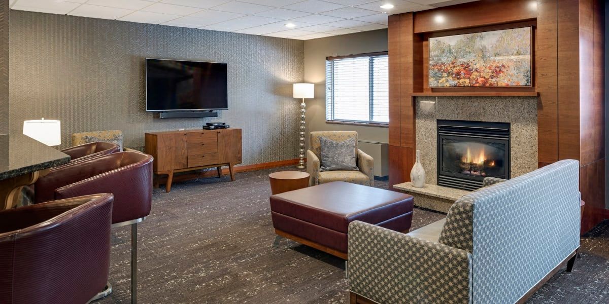 A cozy living room with modern furniture, a television, and a fireplace.