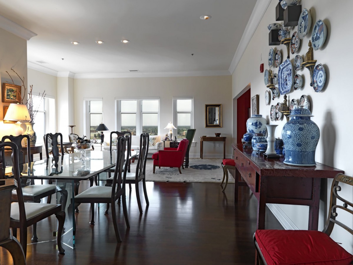 A spacious dining room with elegant furniture and decorative blue vases adorning the walls.