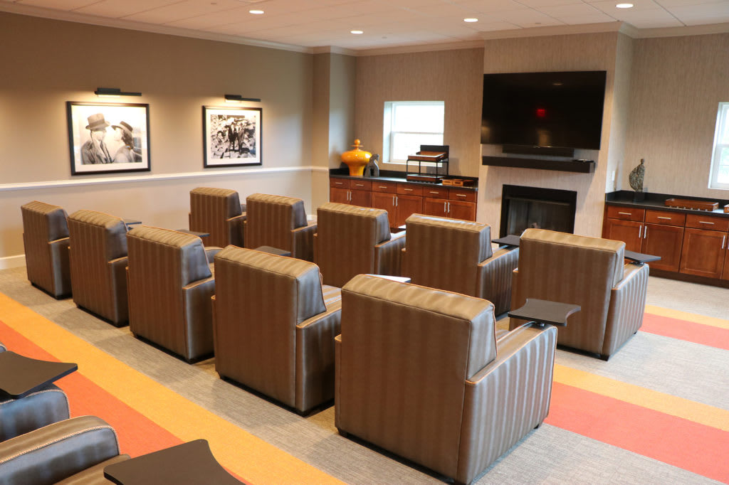 A cozy lounge area with multiple comfortable chairs facing a television.