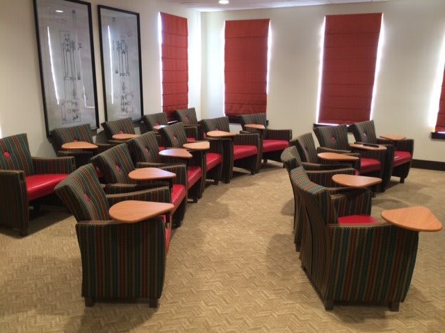 A comfortable waiting area with neatly arranged chairs and small wooden tables.