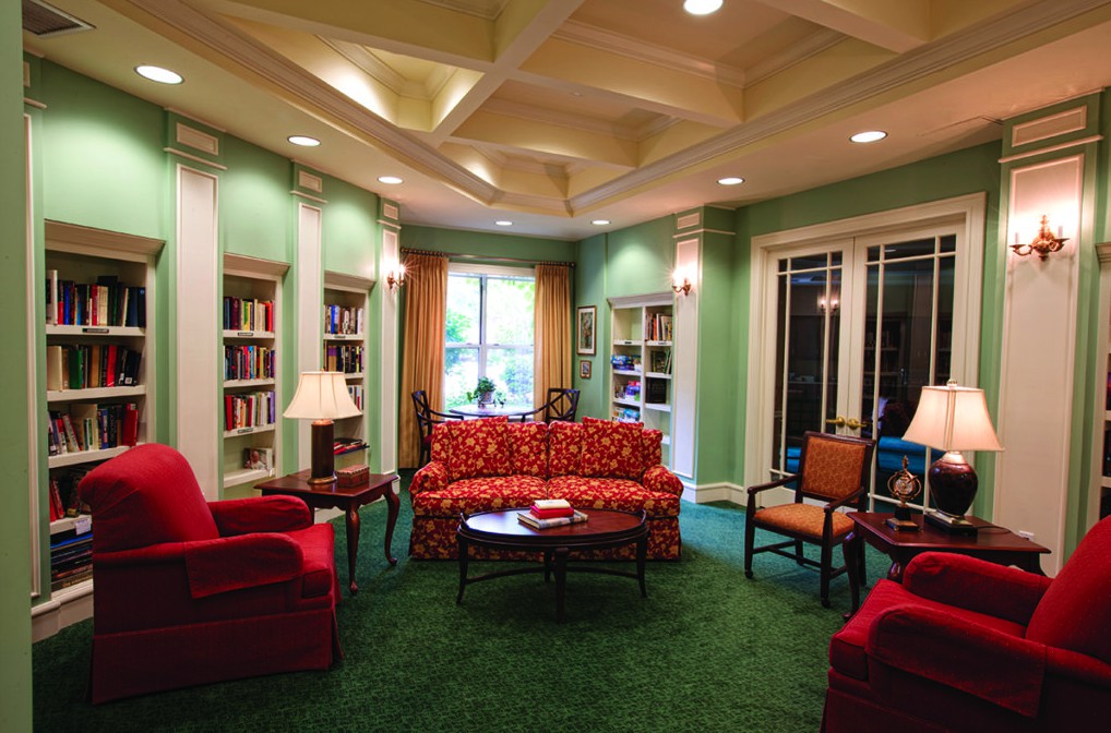 A cozy library living room with colorful furniture and bookshelves.