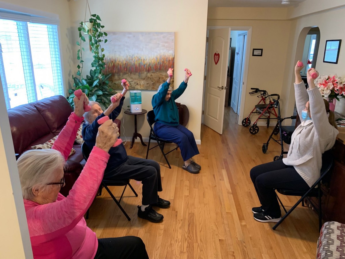 A group of seniors participating in a chair exercise session indoors.
