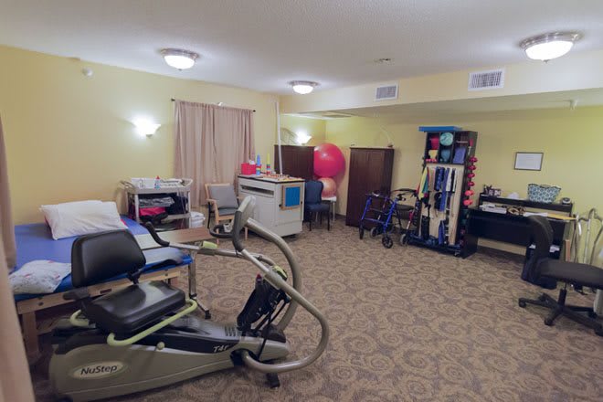 A rehabilitation room equipped with various exercise machines and therapy tools.