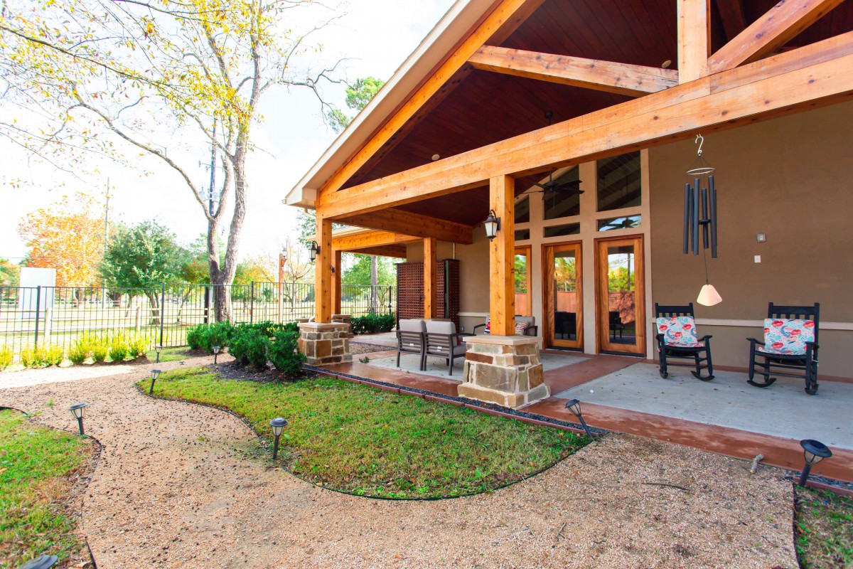 A cozy backyard patio with comfortable seating and wooden architecture.