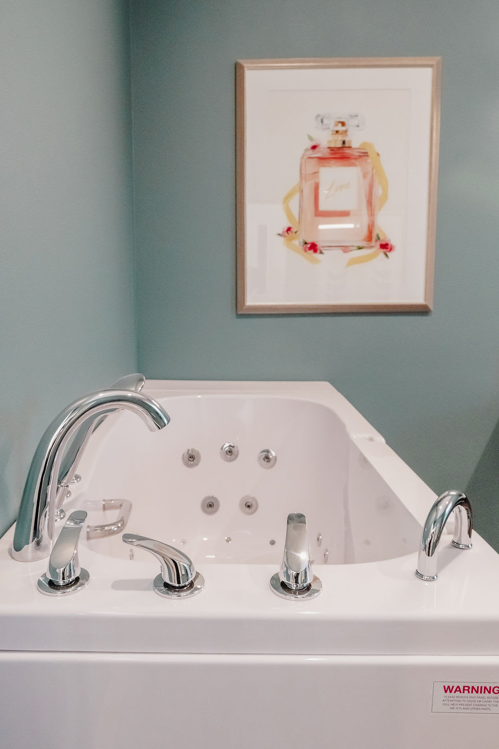 A modern bathroom with a sleek bathtub and wall art.