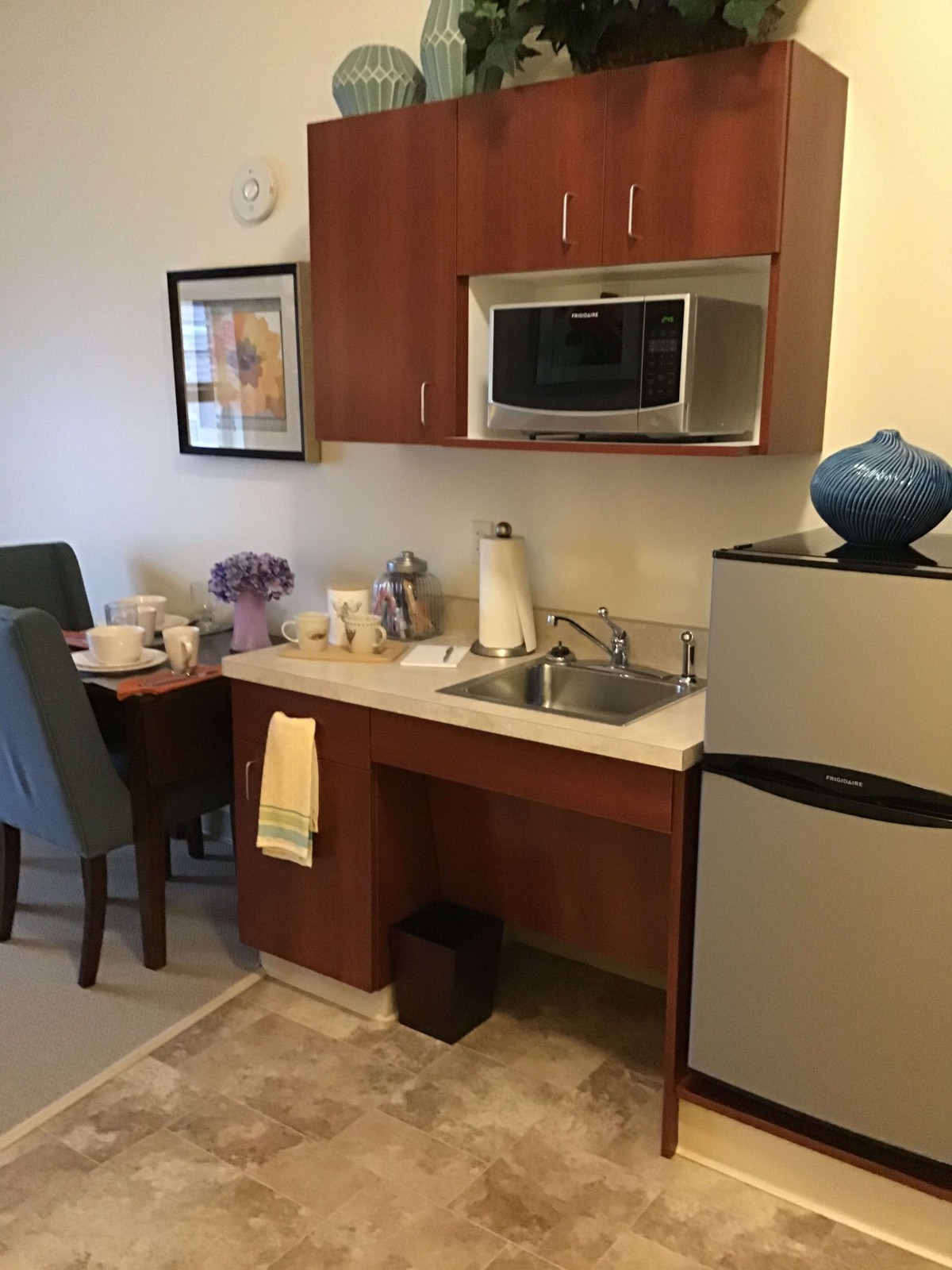A compact kitchenette with modern appliances and a small dining area.