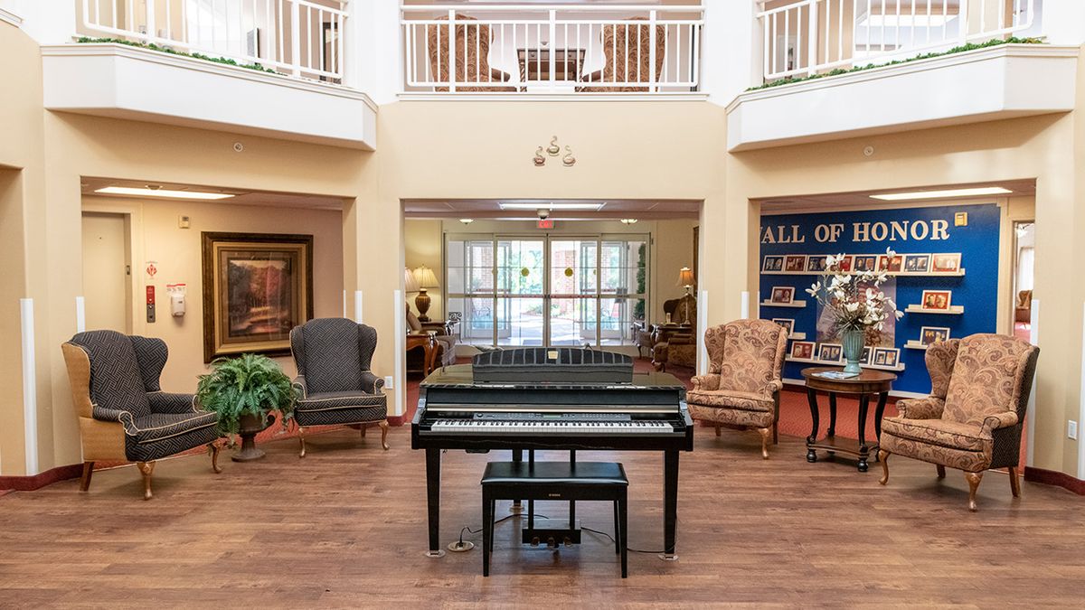 A grand piano in a spacious lobby with elegant furnishings.