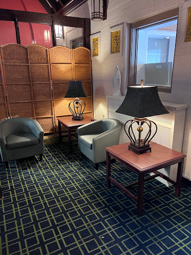 A cozy corner in a lobby featuring comfortable chairs, stylish lamps, and elegant tables.