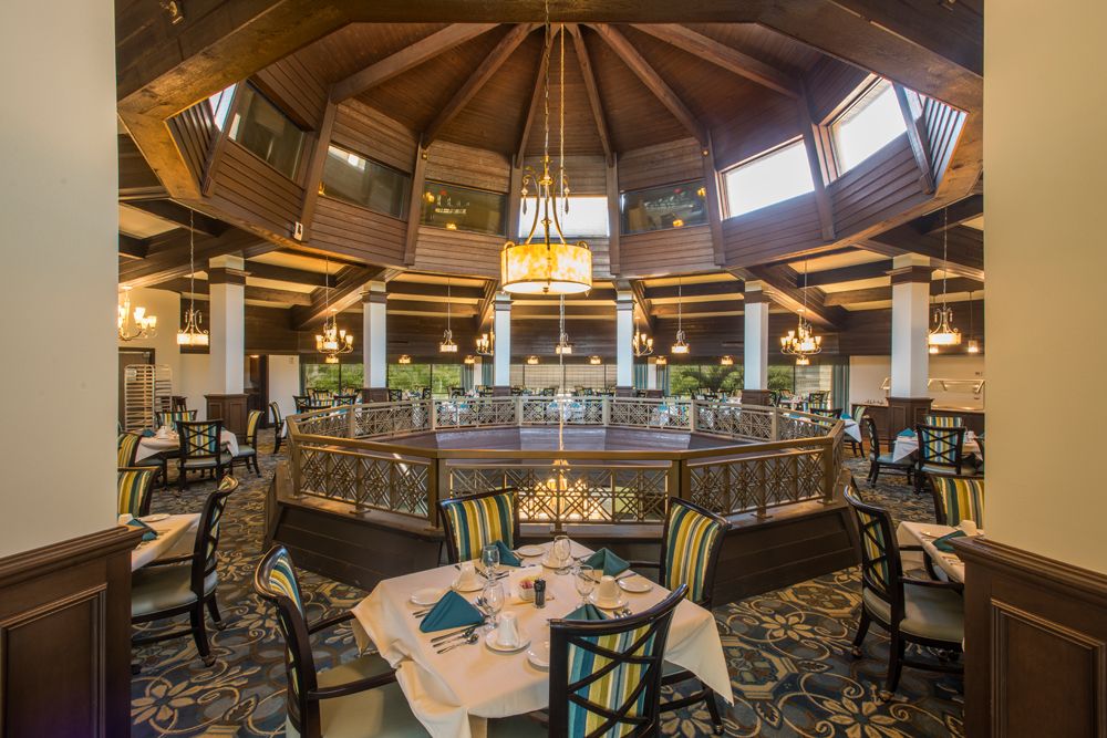 An elegant restaurant interior featuring a central chandelier and well-arranged dining tables.