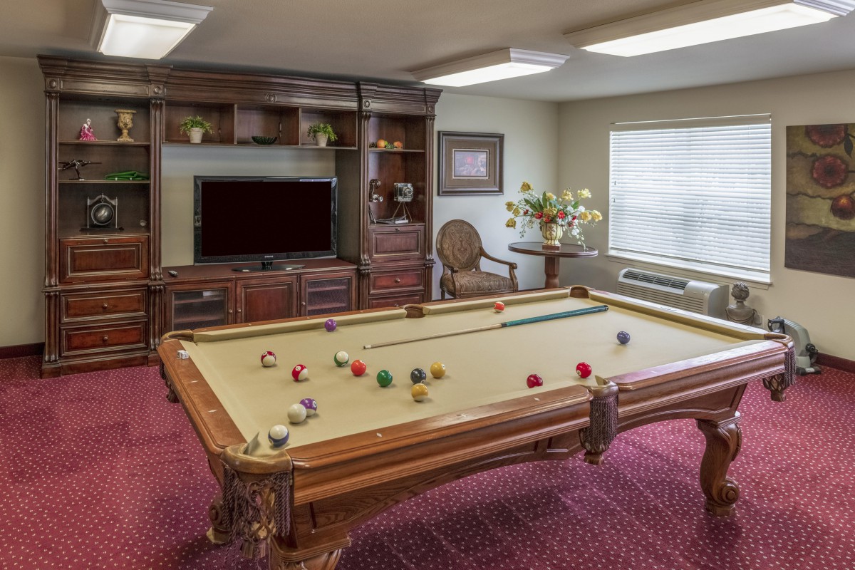 A cozy game room featuring a pool table and entertainment area.